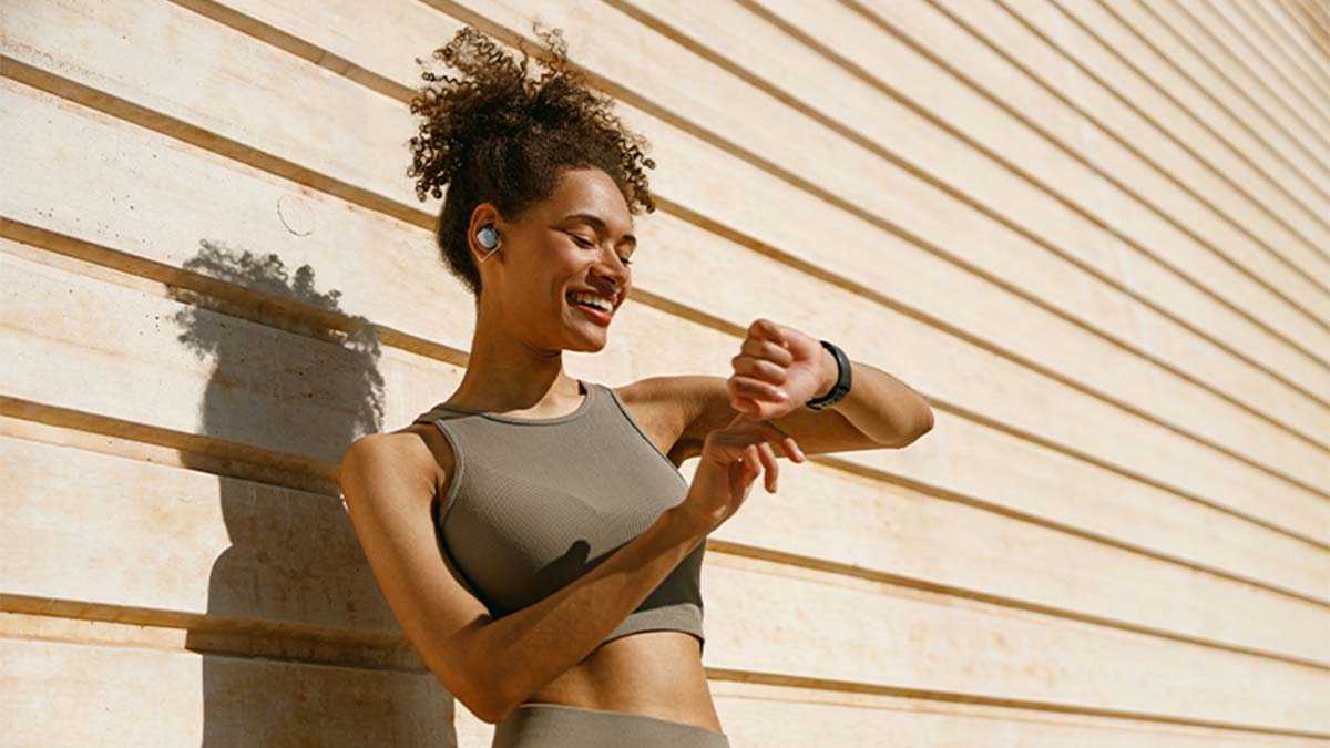 Mulher vestida com roupa desportiva, consulta o smartwatch